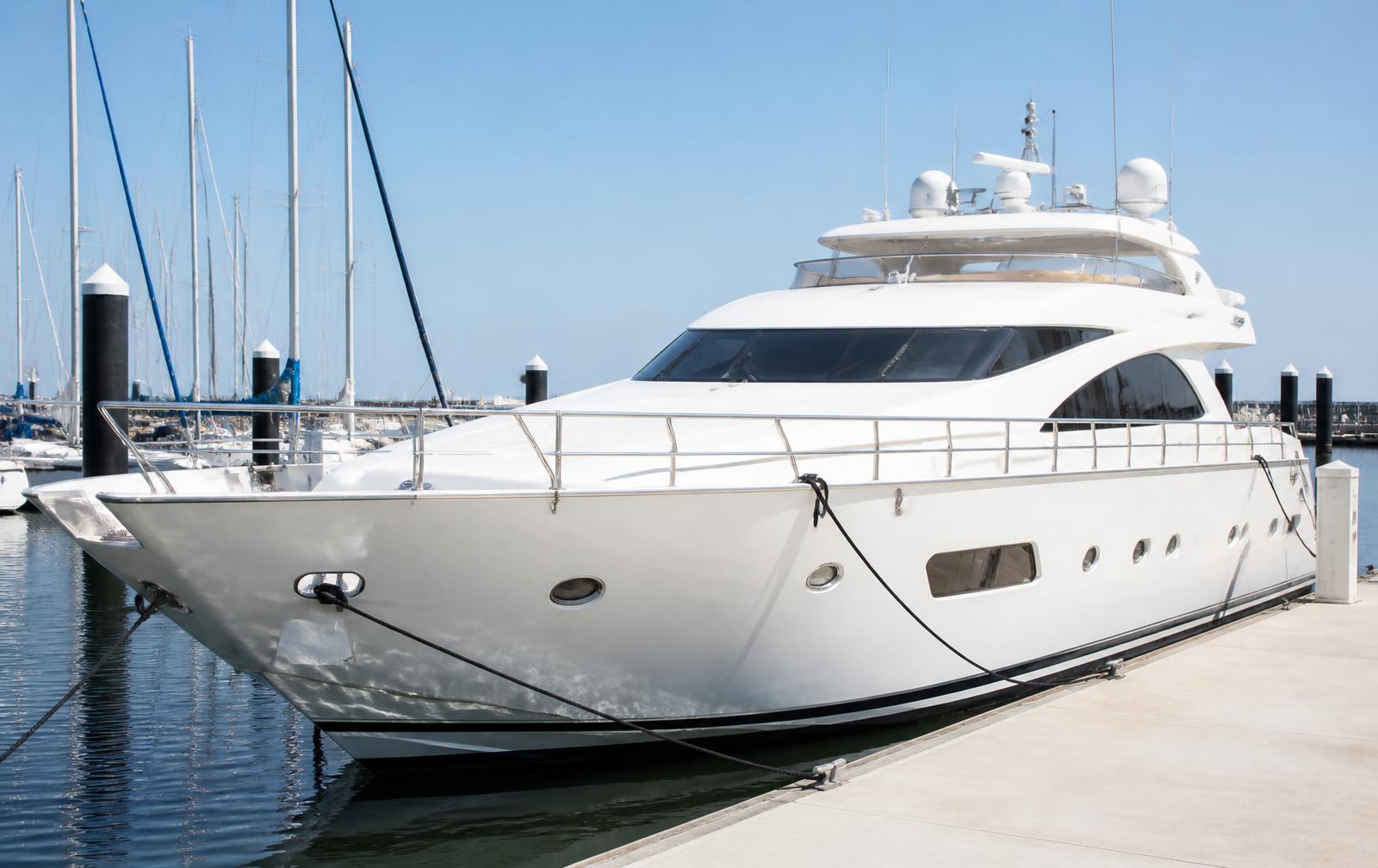 Motor yacht moored alongside a dock in a professional marina